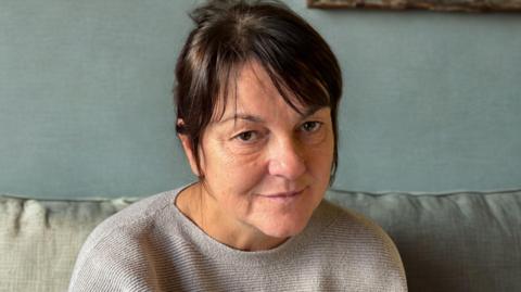 Erica Hay, a middle-aged woman with dark hair.