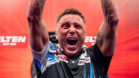 Gerwyn Price raises his arms aloft and shouts in celebration