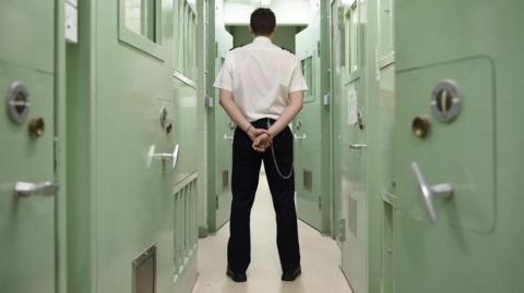 Prison guard standing in front of a door