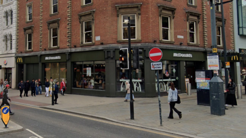 A city centre McDonalds with a green exterior.
