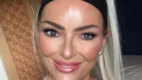 Jennifer Anne Brown has blonde hair and a black headband. She is smiling