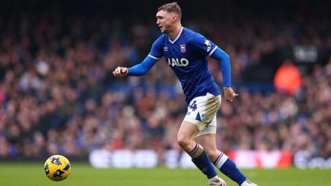 Ipswich midfielder Jack Taylor drives forward with ball at his feet in home kit