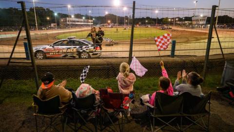 Spectators applaud the winner of a banger race at Arlington Stadium on August 09, 2023.