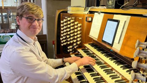 Graham Thorpe playing the organ and smiling