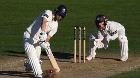 Left-hander Jaydn Denly comes down the wicket to a delivery with wicketkeeper Matty Hurst watching behind the stumps 