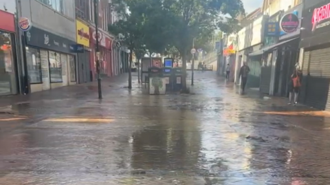 A mobile phone picture showing a pedestrianised shopping street awash with water