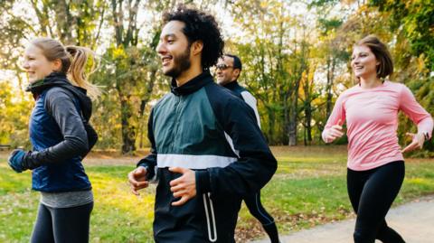 joggers, running through a sunny park
