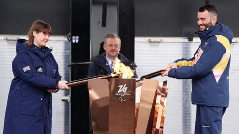 Millie Knight of ParalympicsGB and Andrea Macri of Paralympics Italy light the Paralympic Flame cauldron during the Paralympic flame lighting ceremony for the Milano Cortina 2026 Paralympic Winter Games at Stoke Mandeville Stadium 