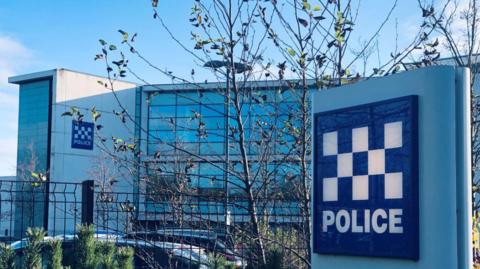 The Northumbria Police headquarters. The multi-storey grey building has two blue signs on it which read: "Police"