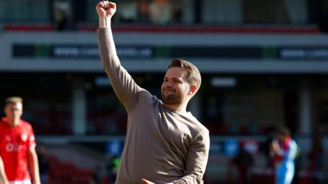 Plymouth Argyle boss Tom Cleverley punching the air in delight towards his side's supporters after their victory against Barnsley.