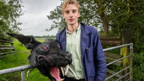 Charlie Cooper with a costume head of the Black Shuck, a ghostly dog that roams East Anglia