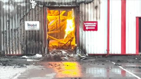 Plumes of smoke and orange flames could be seen rising from Ron Skinner and Sons on the Tarfarnaubach Industrial Estate in Tredegar, Blaenau Gwent. Fire can be seen through the door of the dealership. 