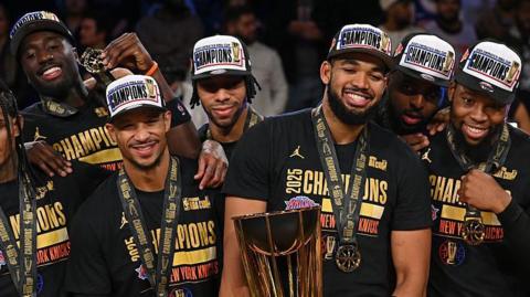 Karl-Anthony Towns holds the NBA Cup trophy besides his team-mates after the New York Knicks beat the San Antonio Spurs
