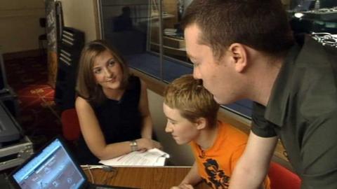 Victoria Derbyshire watches as Charlie Brooker uses a laptop.