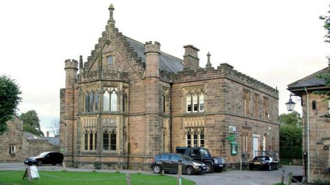 The building was designed in the Gothic Revival style and was built in ashlar stone to resemble a French "Hôtel de Ville"