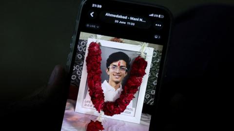 Prashant Patel, 45, shows a photo of his 17-year-old son Kahaan Patel, who took his own life ahead of the NEET exam retest, in Ahmedabad