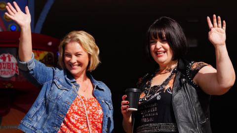 Joanna Page and Ruth Jones smile and wave to crowds of fans while filming in Barry Island