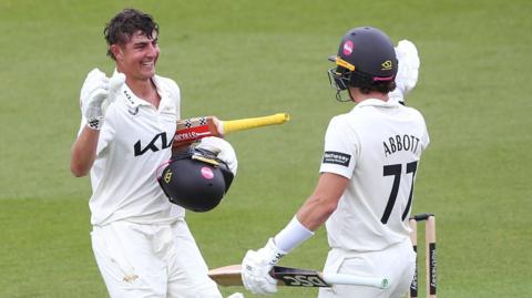 Sean Abbott of Surrey congratulates Adam Thomas after scoring a century against Sussex