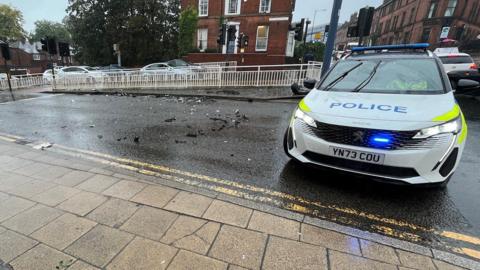 A police car parked sideways on a street