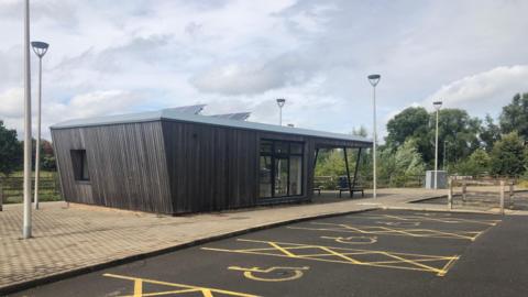 A new-looking bus stop without anyone nearby.