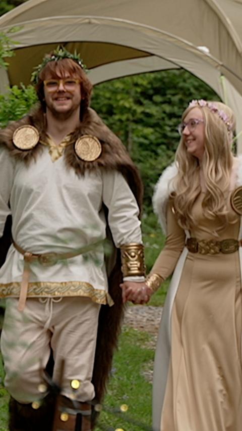 Couple in fantasy costumes holding hands and smiling