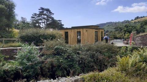 The visitor hub a small wooden building which blends in with the greenery around.