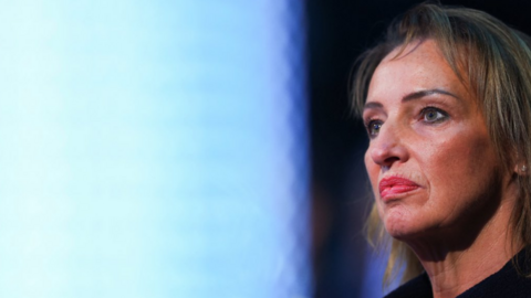 Image shows Runcorn and Helsby MP Sarah Pochin. The Reform UK MP is on the right of the image, with a light blue-coloured screen out of focus in the background.