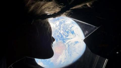 Astronaut Christina Koch watching Earth from the Orion spacecraft.