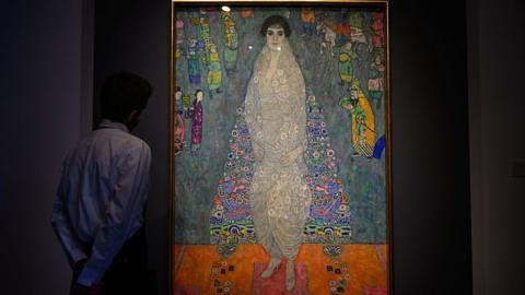 A man looks at Gustav Klimt's Portrait of Elisabeth Lederer with his hands behind his back.