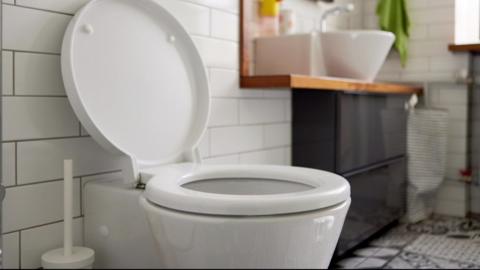 A toilet with the lid open in a bathroom.