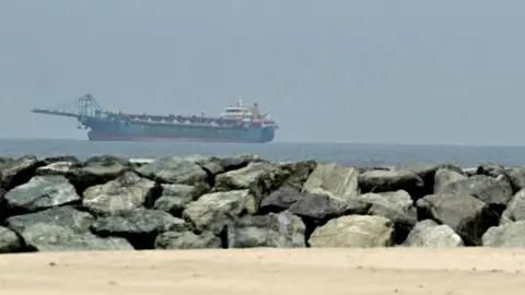  A ship is seen in the Persian Gulf off the coast of Sharjah the day after the failure of US-Iran peace talks on April 13, 2026. 