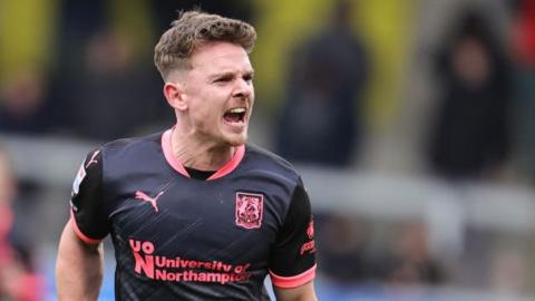 Sam Hoskins celebrates scoring Northampton's winner at Burton