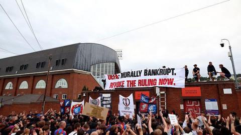Crystal Palace fans protest at Selhurst Park about their demotion to the Uefa Conference League 