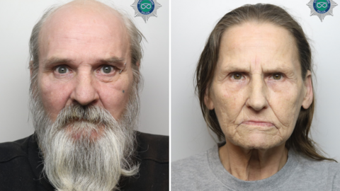 A composite image comprised of two police mugshots. On the left is a man with a long grey beard, and on the right a woman with shoulder length brown hair