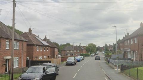 A residential street with cars parked along the street.