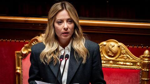 Giorgia Meloni addresses the Italian Senate in Rome, with red velvet chairs behind her