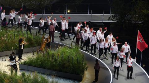 Team Isle of Man waving the Manx flag walk out at the opening ceremony
