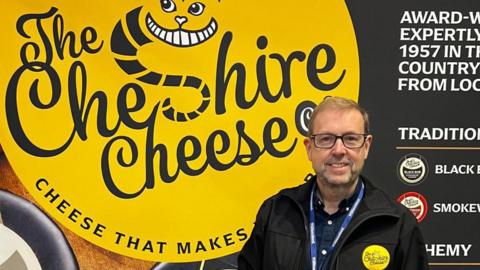 Simon Purrell standing next to a The Cheshire Cheese company sign