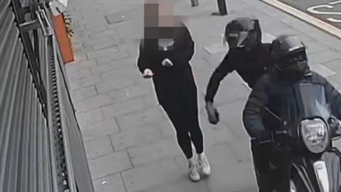 CCTV still shows two people on a moped appearing to attempt to steal a phone from a pedestrian on the pavement. 