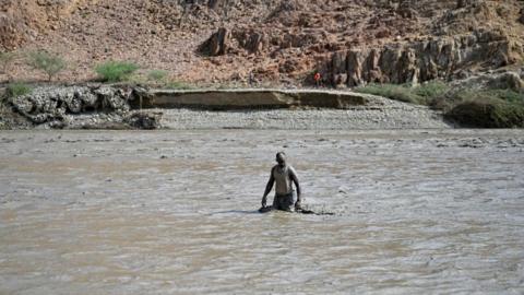 An image of a man wading through water 