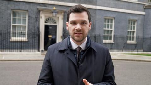 Henry Zeffman in suit, stood outside 10 Downing Street