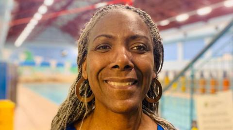 Carol Burrell smiling at the camera pool side