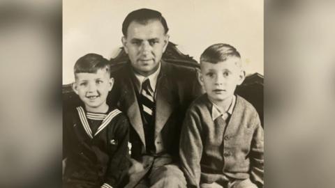 A photograph taken shortly after the war's end showing Peter Herke and his younger brother flanking their father.