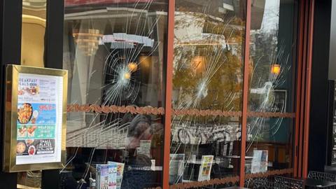 A close-up of a row of windows that have been smashed.