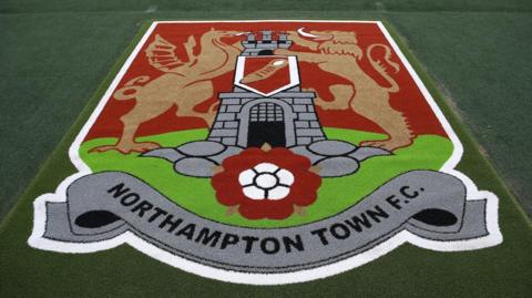 Northampton Town badge on the pitch at Sixfields