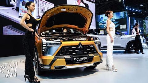 Models pose with a Mitsubishi Xforce HEV car displayed at the 46th Bangkok International Motor Show 2025 in Bangkok, Thailand, on 28 March, 2025.