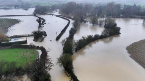 The flooded area around Barcombe Mills Road in Lewes, East Sussex, following huge rainfall on Sunday 5 January. Water has risen up in a number of fields and a number of trees and bushes can be seen peaking out from the flooded area.