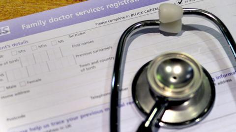 Image shows a stethoscope resting on an NHS registration card