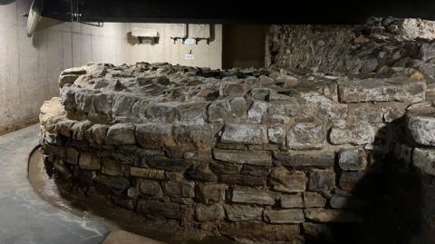 The remains of a medieval defensive tower, a round solid stone structure.