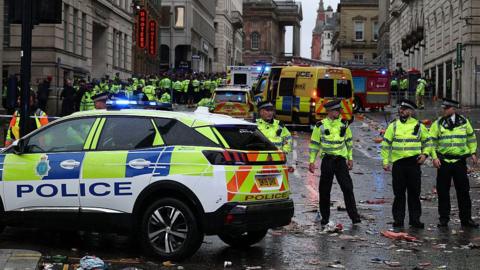 Police officers stand on duty at a cordon at the entrance to Water Street, at the scene of an incident, which happened during the open-top bus victory parade for Liverpool's Premier League title win.